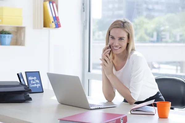 Hermosa joven mujer de negocios en la oficina hablando por teléfono — Foto de Stock