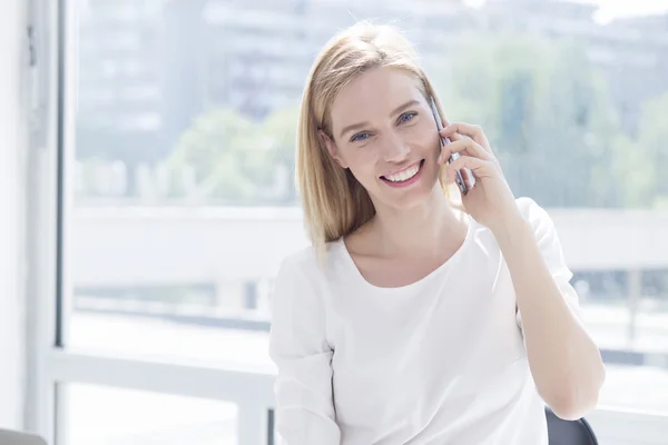 Mulher de negócios jovem bonita no escritório falando por telefone — Fotografia de Stock