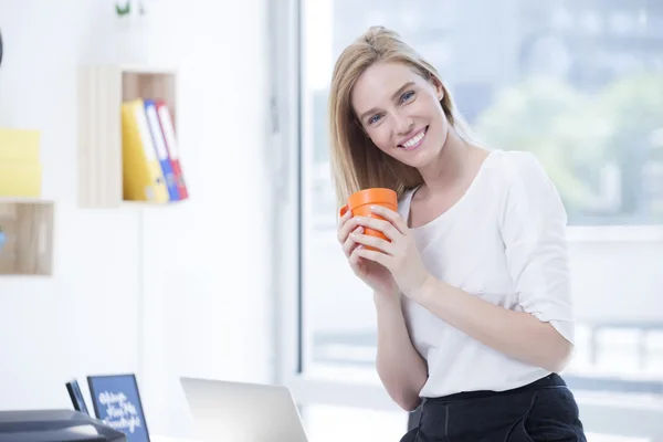 Beautiful Blond Business woman in Office drink Coffee