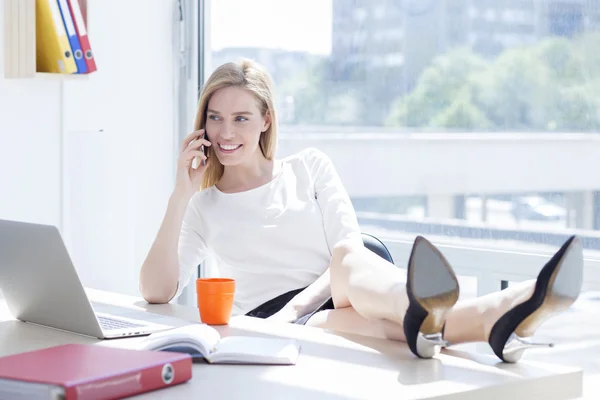 Деловая женщина в офисе разговаривает по телефону — стоковое фото
