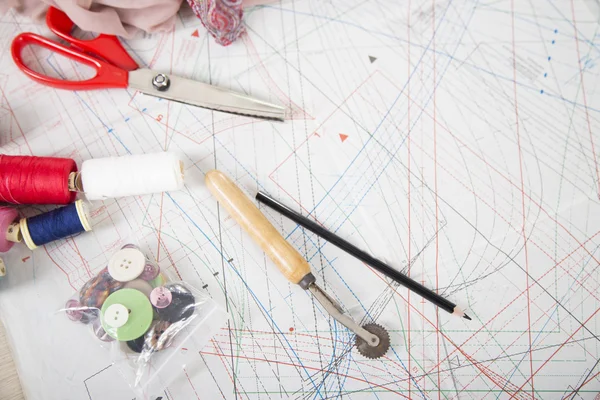 Cucire sfondo. Accessori per cucire e su un modello di carta . — Foto Stock