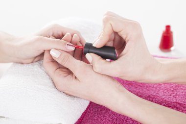 Kadın parmak çivi için kırmızı tırnak vernik uygulama. 