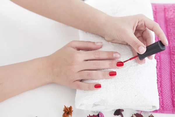 Vrouw rode nagel lak toe te passen op vinger nagels. — Stockfoto