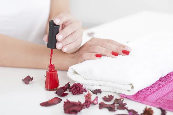 Vrouw rode nagel lak toe te passen op vinger nagels. — Stockfoto