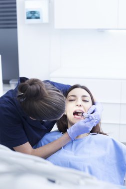 Diş tedavisi dişçi ofisinde sahip güzel bir kadın hasta