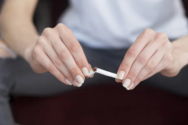 Закрыть женские руки со сломанной сигаретой. Бросить курить — стоковое фото