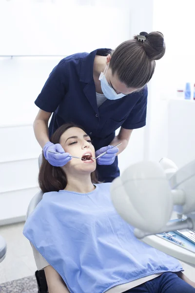 Hermosa paciente mujer que tiene tratamiento dental en el consultorio del dentista —  Fotos de Stock