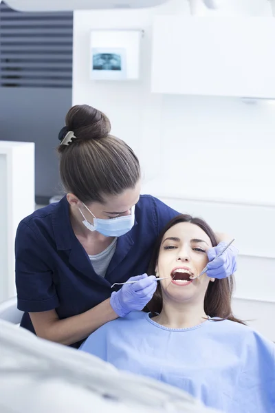 Красивая пациентка, проходящая стоматологическое лечение в кабинете стоматолога — стоковое фото