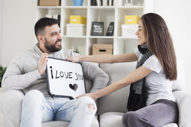 Genç çift gösterilen Beyaz tahtada yazılı mesaj seviyorum. Sana mesaj seviyorum. 