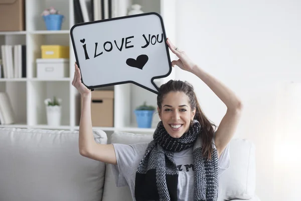 woman holding white board with \'I love you\'