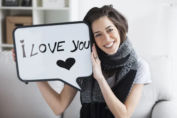 Mulher segurando placa branca com 'Eu te amo' — Fotografia de Stock