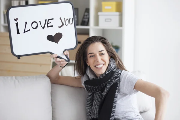 Woman holding white board with 'I love you' — ストック写真
