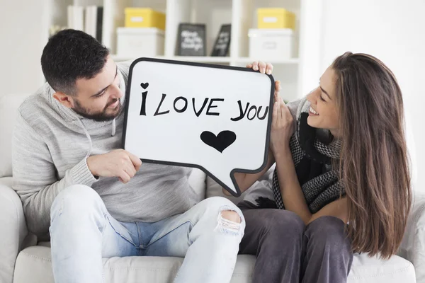 Pareja joven mostrando mensaje de amor escrito en pizarra blanca. Te amo mensaje . —  Fotos de Stock