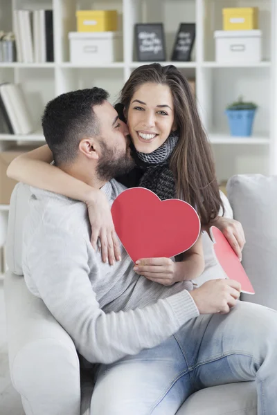 Couple kissing behind paper heart — Stock Photo, Image