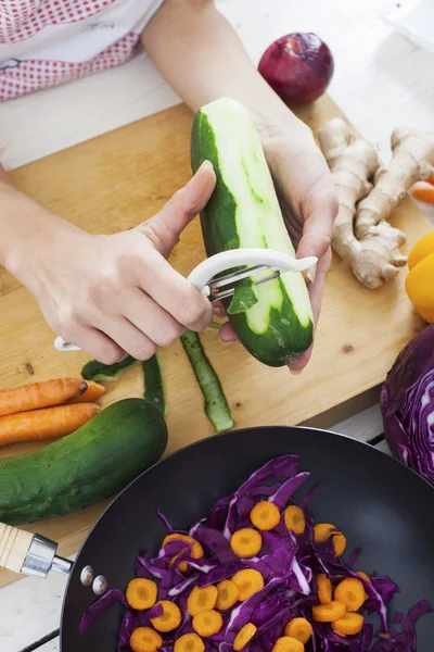 Händer peeling gurka. — Stockfoto