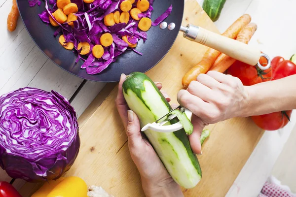 Manos pelando pepino. Preparación para ensalada o wok.Healthy verduras —  Fotos de Stock