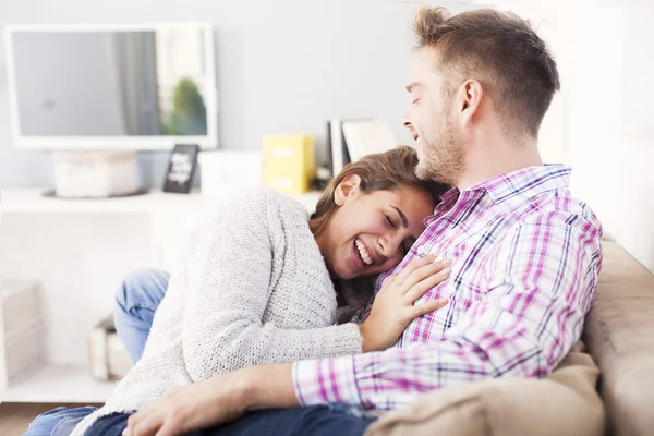 Para przytulanie na kanapie — Zdjęcie stockowe