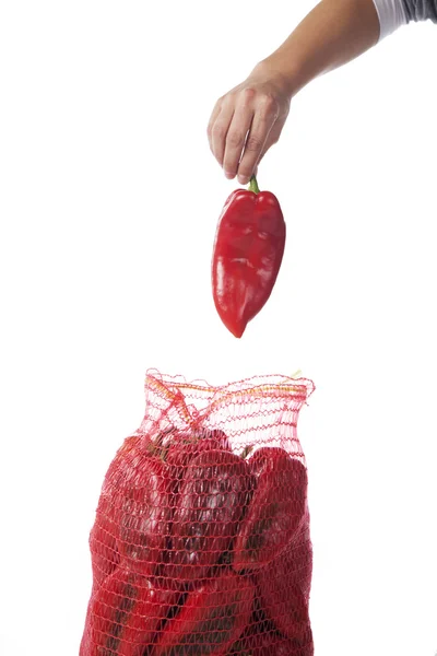 Κόκκινες πιπεριές σε μια τσάντα τσουβάλι σε άσπρο φόντο — Φωτογραφία Αρχείου