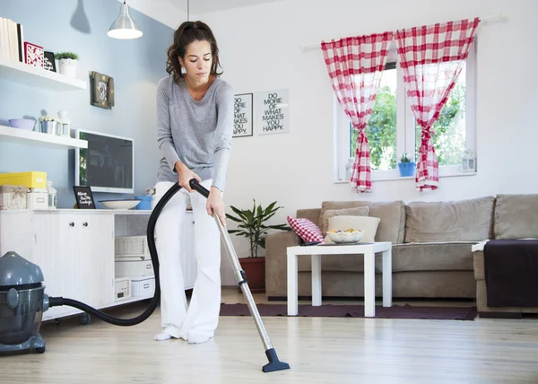 Young opgewonden vrouw reinigen met een stofzuiger — Stockfoto