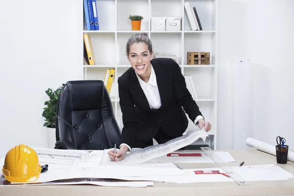 Arquiteto feminino estudando planos no escritório — Fotografia de Stock