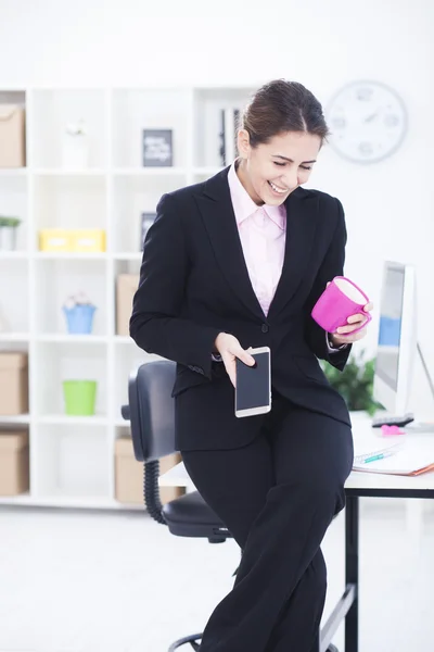 Бізнес-леді посміхається з телефоном — стокове фото