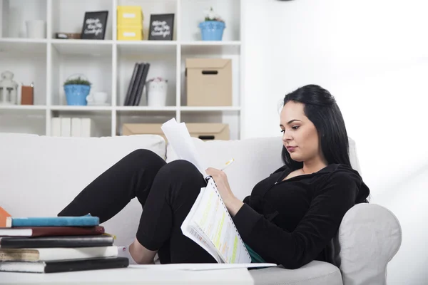 Student studying on couch at home Royalty Free Stock Photos