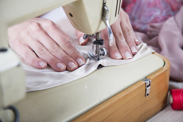 Женские руки за шитьем
