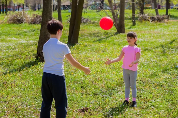Ragazzo e ragazza giocare con palla in parco — Foto Stock