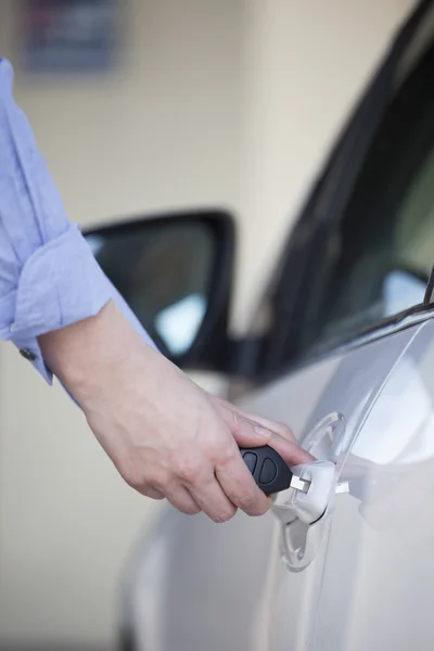 Vrouw die auto deur met sleutel — Stockfoto