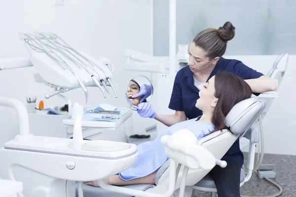 Mooie vrouw patiënt tandheelkundige behandeling gelet op het kantoor van tandarts — Stockfoto