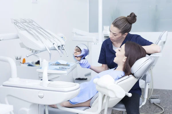 Mulher bonita paciente tendo tratamento dentário no consultório do dentista — Fotografia de Stock