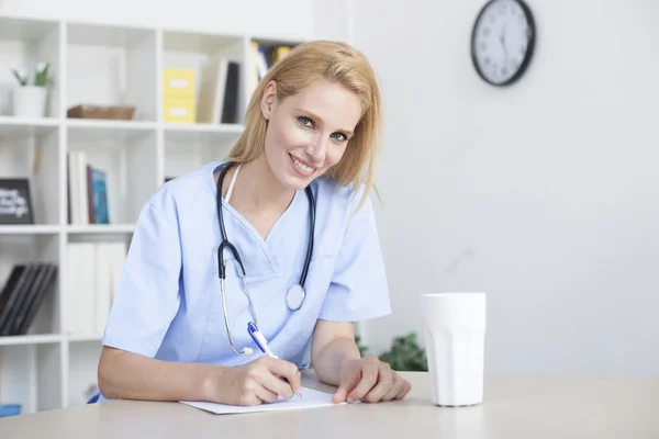 Kvinnliga läkare sitter office desk arbetar — Stockfoto