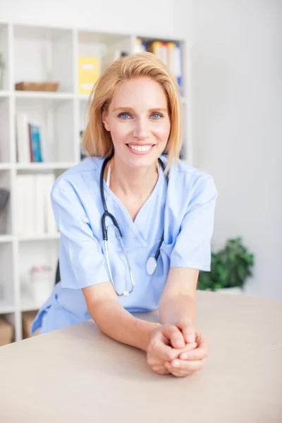 Young female doctor and practitioner working at desk — Stock Photo, Image