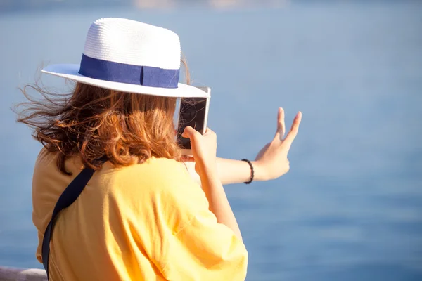 Visão traseira de uma mulher tirando foto com uma câmera de telefone inteligente no mar — Fotografia de Stock
