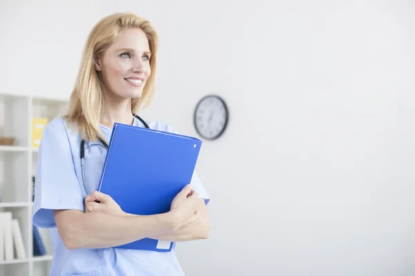 Young female doctor and practitioner working at desk — Stock Photo, Image