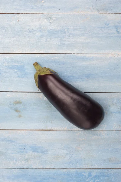 Aubergine op een blauwe houten bord, bovenaanzicht — Stockfoto