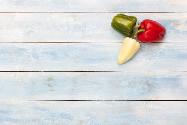 Kleurrijke paprika's op houten bord — Stockfoto
