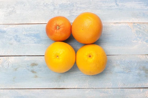 Grapefruits en sinaasappelen op houten planken — Stockfoto