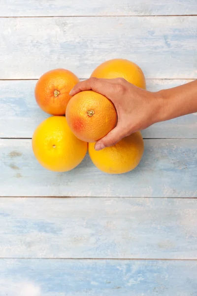 Грейпфрути, апельсини і рука — стокове фото