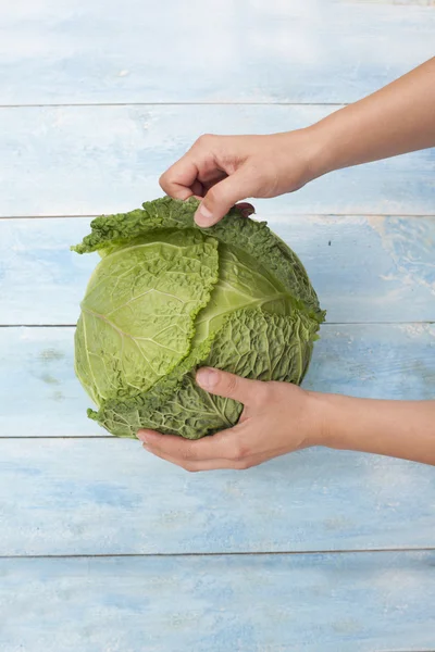 Kale in hands on wooden board — Stock Image Kale in hands on wooden board Stock Photo