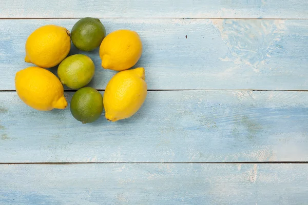 Zitrusfrüchte auf einem alten blauen Holzbrett — Stockfoto