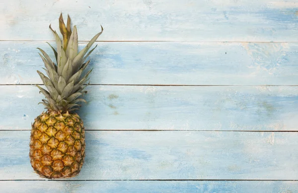 Ananas op blauwe houten bord — Stockfoto