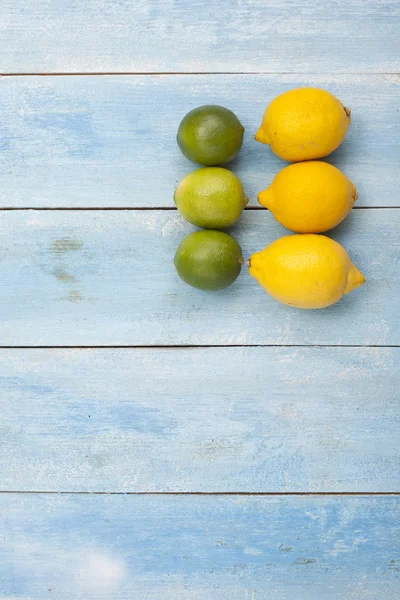 Zitrusfrüchte auf einem alten blauen Holzbrett — Stockfoto