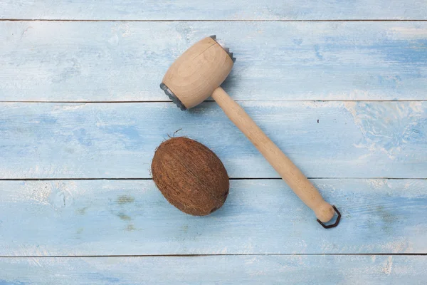 Coco e um martelo isolado em tábua de madeira — Fotografia de Stock