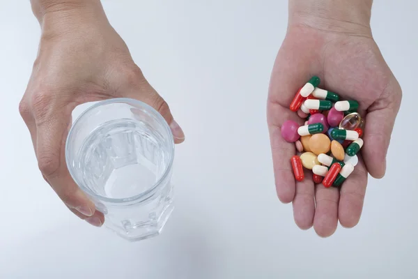 Жіночі руки зі склянкою води і таблетки — стокове фото