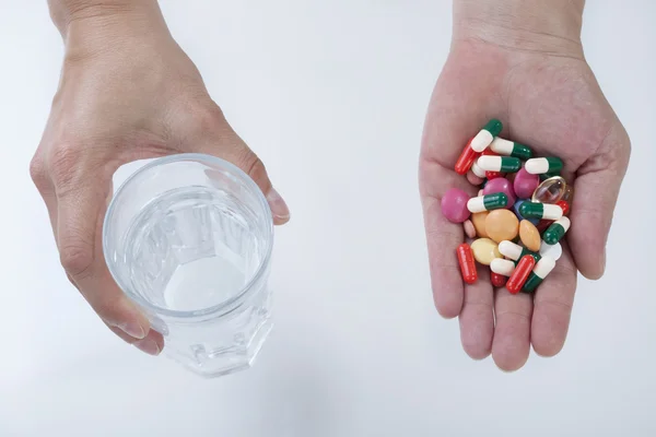 Жіночі руки зі склянкою води і таблетки — стокове фото