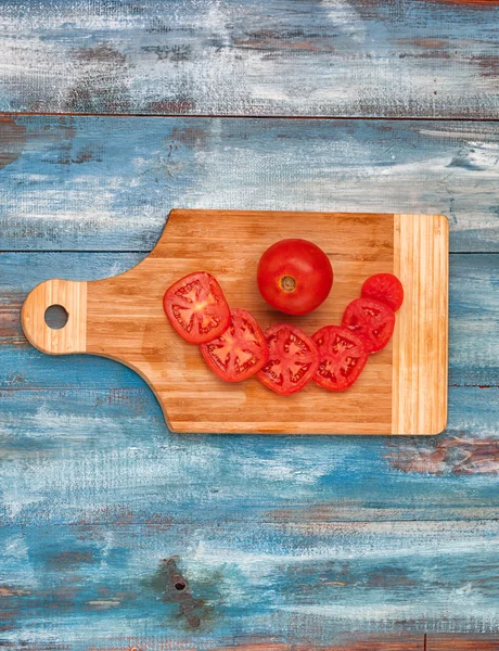 Tomates en rodajas sobre una tabla de madera vieja —  Fotos de Stock