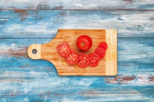 Tomates fatiados em uma prancha de madeira — Fotografia de Stock