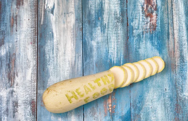 Цукіні на старій дошці з вигравіруваним реченням "Здорове харчування " — стокове фото