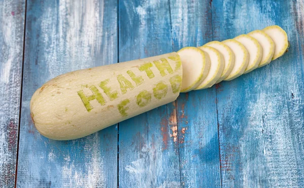 Цукіні на старій дошці з вигравіруваним реченням "Здорове харчування " — стокове фото